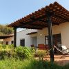 Patio esterno con sedie e vegetazione.