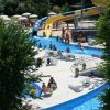 Parco acquatico con scivoli e piscina affollata.