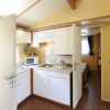 Cucina compatta con elettrodomestici e bagno a vista.