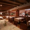 Un ristorante con tavoli apparecchiati, sedie in legno e soffitto a travi di legno.