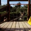 Parco giochi con scivolo giallo e rete da arrampicata. Due bambini giocano.