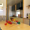 Interno di una casa mobile con cucina e tavolo, decorato con frutta e bottiglie.