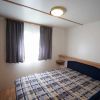 Una camera da letto con un letto matrimoniale, tende scure e arredamento minimalista.