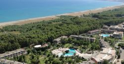 Resort costiero con piscine, giardini e spiaggia vicina.