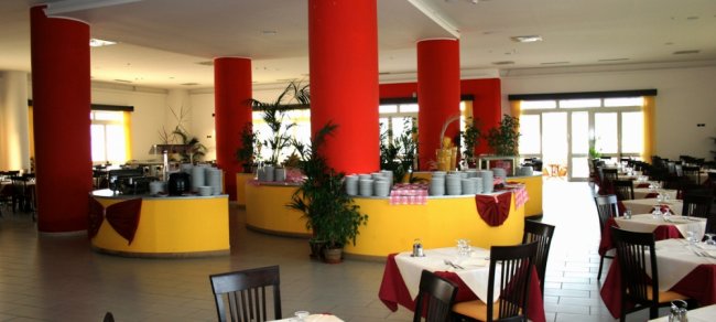Ristorante ampio con colonne rosse e tavoli apparecchiati.