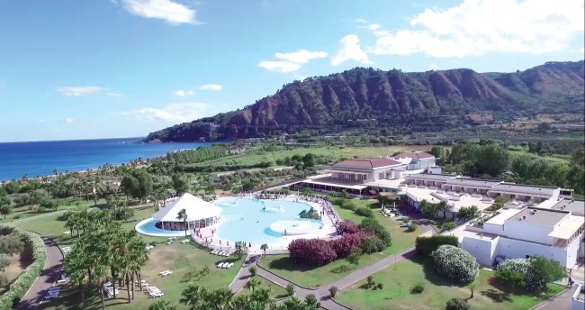 Resort con piscina e vista su colline e mare.