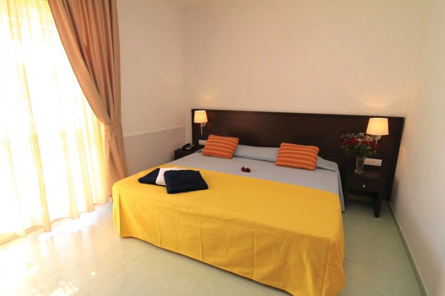 Camera da letto con letto matrimoniale e cuscini a righe.