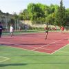 Un campo sportivo all'aperto con persone che giocano a calcio.