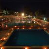 Piscina illuminata di notte con luci intorno.