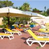 Lettini gialli sotto ombrelloni vicino alla piscina.