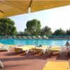 Piscina circondata da lettini e ombrelloni gialli.
