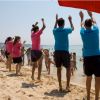 Persone che ballano sulla spiaggia in riva al mare.
