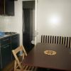 Cucina compatta con tavolo e sedute a righe.