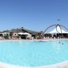 Piscina ampia con pochi bagnanti e strutture in lontananza.