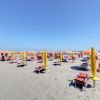Spiaggia con ombrelloni gialli e lettini.