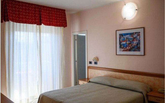 Camera da letto con letto matrimoniale e finestra ampia.