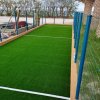 Campo da gioco con erba sintetica e recinzione.