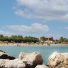 Spiaggia con mare calmo e ombrelloni.