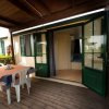 Terrazza con tavolo apparecchiato e ingresso.