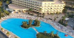 Piscina grande a forma di cuore circondata da un hotel con molte stanze.