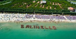 Spiaggia affollata vista dall'alto con scritta 