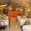 Ristorante con archi in mattoni e tavoli apparecchiati con tovaglie bianche.