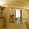 Cucina e soggiorno moderno con divano e TV.