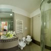 Bagno elegante con doccia, lavandino e fiori.