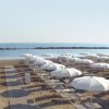 Spiaggia con ombrelloni bianchi.