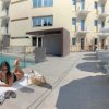 Donna su terrazza con piscina e lettini.