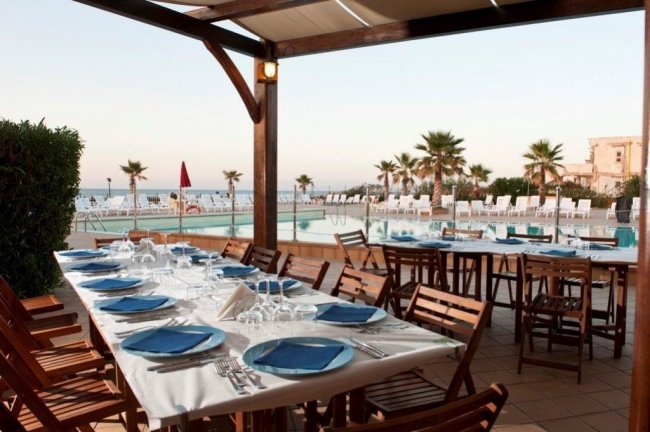 Tavoli apparecchiati vicino a una piscina.